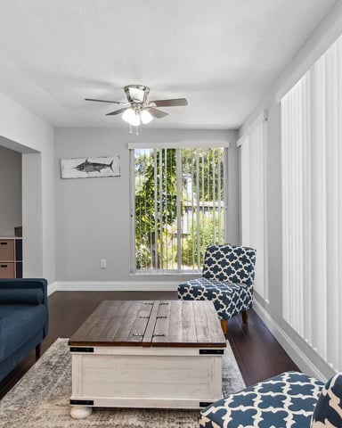 Open-plan coastal living room with blue striped sofas and wood flooring